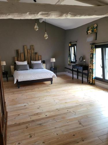 1 dormitorio con 1 cama y suelo de madera en Au Clos Des Dély - Chambre d Hôtes Référence, en Mareuil