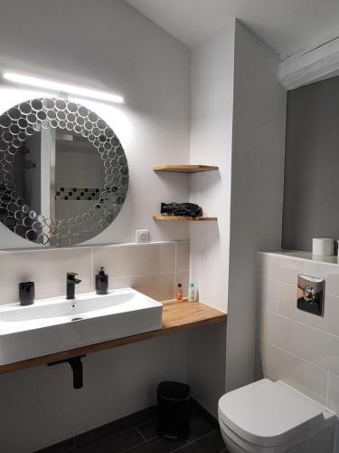 y baño con lavabo blanco y espejo. en Au Clos Des Dély - Chambre d Hôtes Référence, en Mareuil
