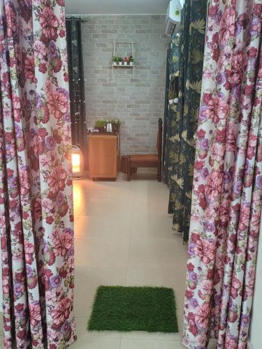 a living room with curtains and a green rug at Dhairya's Villa Home Away From Home in Jammu