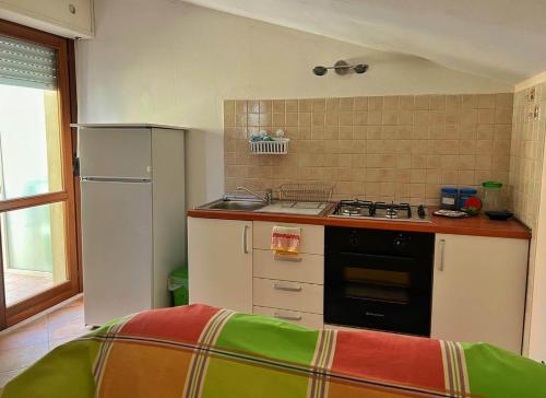 a small kitchen with a stove and a refrigerator at Bilocale vicino Aeroporto in San Giovanni Teatino