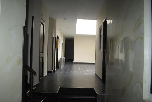 a hallway with black doors and a tile floor at Hotel Mi Palermo in Bucaramanga