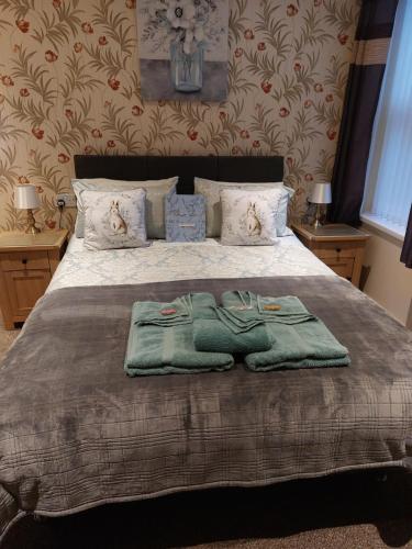 a bedroom with a bed with two towels on it at PONDEROSA in Blackpool