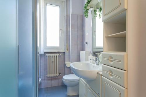 bagno con lavandino, servizi igienici e finestra di Duomo 15 minuti a Milano