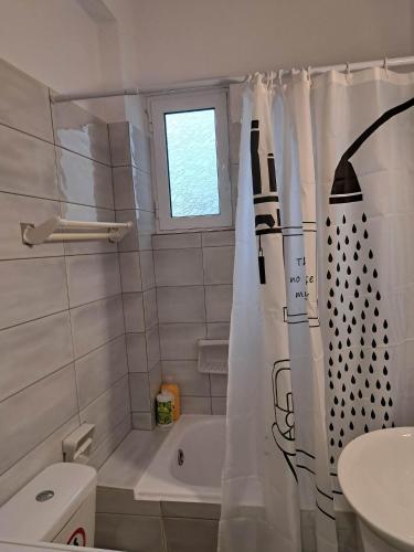 a bathroom with a tub and a shower curtain at Mary's Home Center City F in Aigio