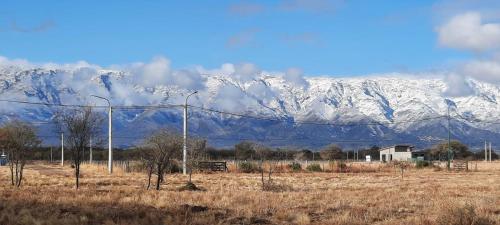 a snow covered mountain range with a field and street lights at Casa del sol in Cañada La Negra