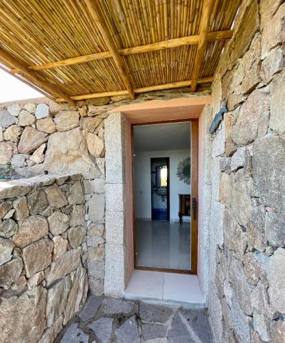 a stone wall with a wooden ceiling and a doorway at Villa Kalypso - Porto Cervo in Porto Cervo