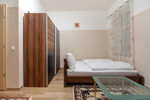a small bedroom with a bed and a glass table at Ruhiges Apartment in 15 Min zum Zentrum in Vienna