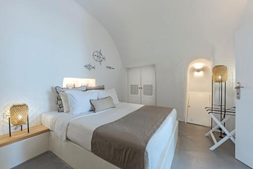 a white bedroom with a large bed in it at Helianthus Dream Homes in Oia