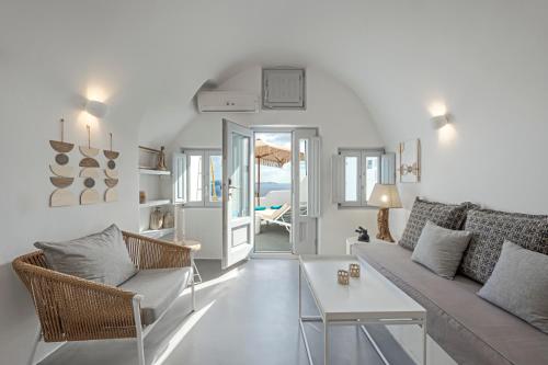a living room with a couch and chairs and a table at Helianthus Suites- Caldera Caves in Oia