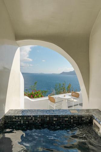 a pool in a house with a view of the ocean at Helianthus Dream Homes in Oia