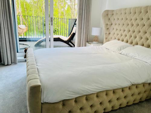 a bedroom with a large bed and a balcony at Glasgow City Central Executive Triplex House, 3 Bedroom 3 Bathrooms 1 living room Kitchen - Huge Terrace for Master Bedroom - Private E Parking LEZ Congestion Zone Free - Garden - 5 mins drive to City Centre Central Station in Glasgow