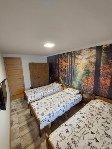 - 3 lits dans une chambre avec un tableau mural dans l'établissement Luxury Apartment Zimska idila, à Bjelašnica