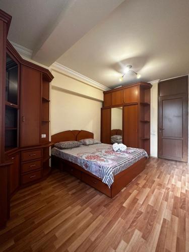 a bedroom with a bed and a wooden floor at Nice Apartment in Koghbaci Street in Yerevan