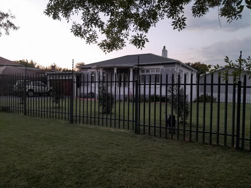 a black metal fence in front of a house at The Cradle's Rest Guest House in Krugersdorp