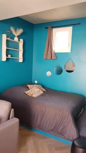 une chambre bleue avec un lit et une fenêtre dans l'établissement Studio cosy au coeur du centre historique, à Montpellier