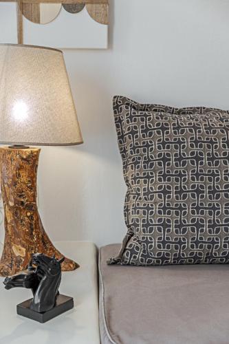 a lamp on a table next to a pillow at Helianthus Dream Homes in Oia