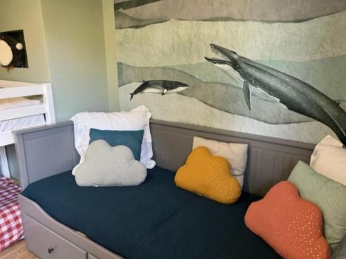 - une chambre avec un lit avec des oreillers et un tableau dans l'établissement Maison Les Géraniums, à Mers-les-Bains