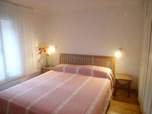 ein Schlafzimmer mit einem großen Bett mit einer rosa Decke in der Unterkunft Calle Burchio in Grado