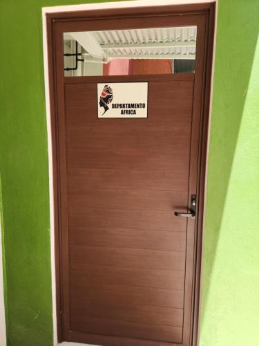 una puerta de madera con un cartel en Apartamento Africa, en Palenque