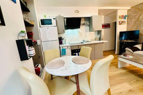 - une cuisine et une salle à manger avec une table et des chaises dans l'établissement Appartement Jardin du Palais- Relaxation Centrale, au Palais