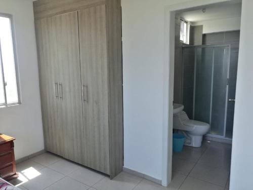 a bathroom with a toilet and a wooden cabinet at Apartment in Sirenis Atacames in Tonsupa