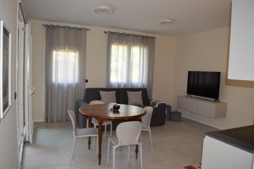 ein Wohnzimmer mit einem Tisch und einem Sofa in der Unterkunft MyVilla - Ivrea via Jervis 22b in Ivrea