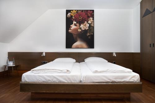 Schlafzimmer mit einem Bett mit Wandgemälde in der Unterkunft Stadthotel Heilbronn in Heilbronn