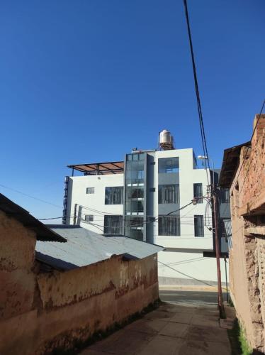 a large white building in the middle of a street at Roma Hostal in Juliaca