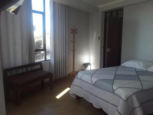 a bedroom with a bed and a window at Roma Hostal in Juliaca