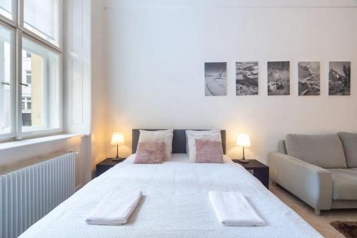 a bedroom with a large white bed and a couch at Old Town Square Luxury Apartment in Prague