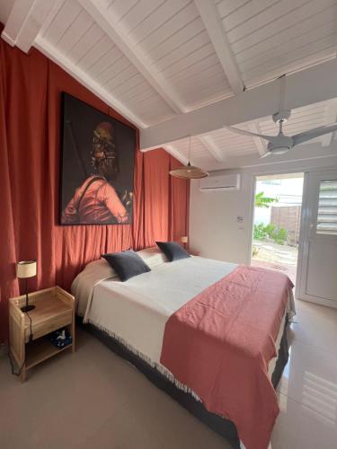 a bedroom with a large bed with a painting on the wall at Sweet Home SXM Baie Nettlé Pieds dans l'eau in Saint Martin