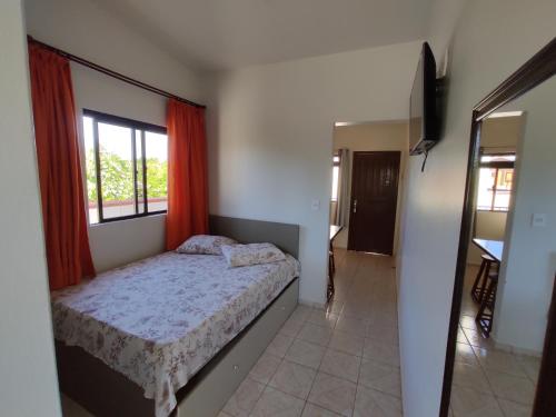 1 dormitorio con cama y ventana en Residencial Medeiros en Guarda do Embaú