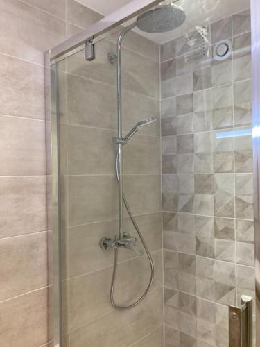 une douche avec une porte vitrée dans une salle de bain dans l'établissement *Horizon Bleu* Les pieds dans l'eau*, à La Grande Motte