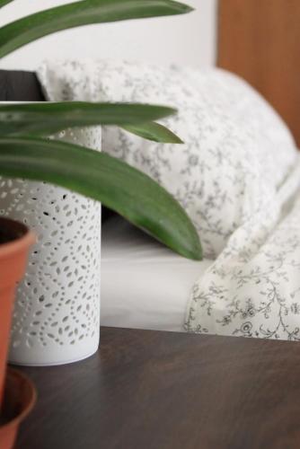 a stack of white pillows on a table with a plant at Green Park Rooms Brno in Brno
