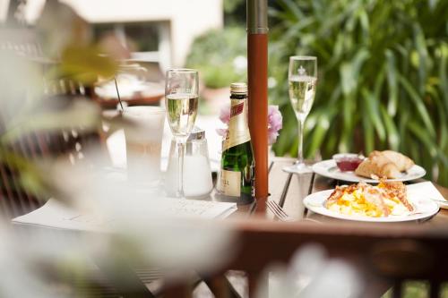 a table with a plate of food and glasses of wine at THE GATE GARDEN Hotel in Berlin
