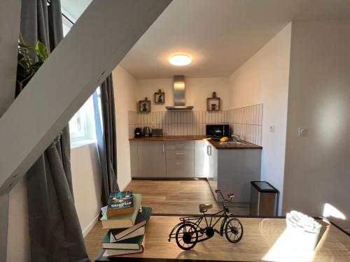 a bike parked in a living room with a kitchen at Nid douillet T2 rénové climatisé centre in Brive-la-Gaillarde