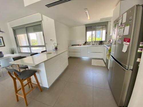 a kitchen with a refrigerator and a table in it at Herzliya Luxury On The Park in Herzliya