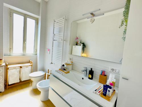 y baño con lavabo, aseo y espejo. en Gemelli-San Pietro-Trastevere-casa con posto auto en Roma