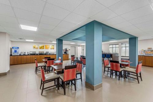 una sala da pranzo con tavoli, sedie e colonne blu di Comfort Inn US Hwy 80 a Demopolis