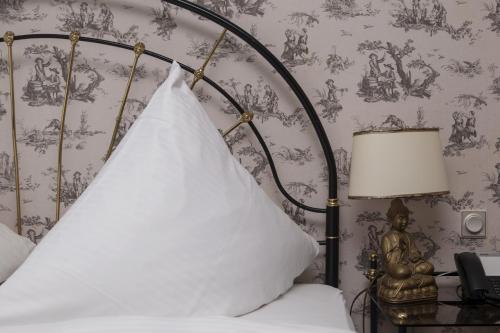 a bedroom with a bed with a pillow on it at Hotel Zum Alten Brunnen in Rheine