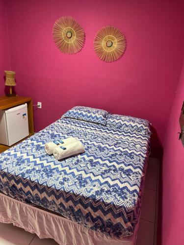 een slaapkamer met een bed met paarse muren en 2 spiegels bij Pousada Vila Milagres in São Miguel dos Milagres