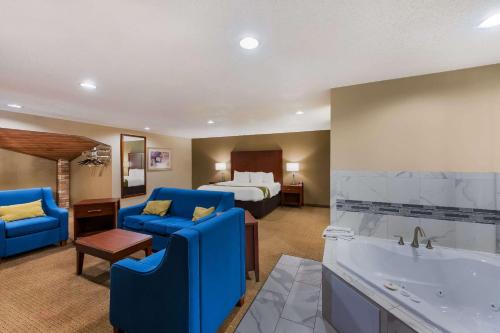 um grande quarto de hotel com uma cama e uma banheira em Quality Inn em Marysville