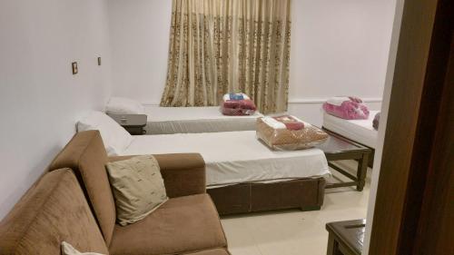 a living room with two beds and a couch at Al Namteh Lodge in ‘Ābil