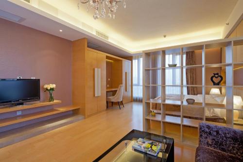 uma grande sala de estar com uma cama e uma televisão em Beijing Xinxiang Yayuan Apartment (Sanlitun) em Pequim