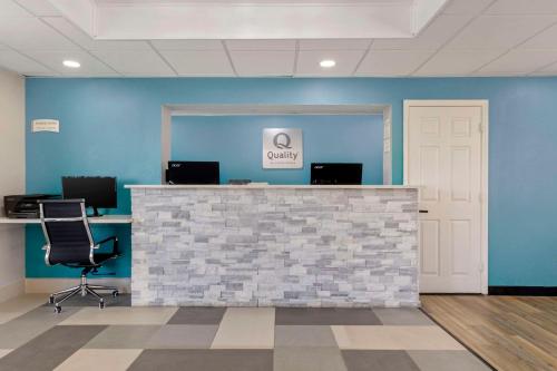 an office with blue walls and a counter with chairs at Quality Inn in Newberry