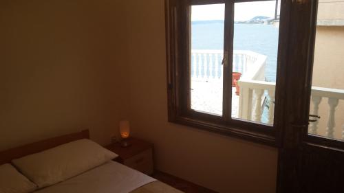 a bedroom with a window with a view of the ocean at Apartment Gevera in Split