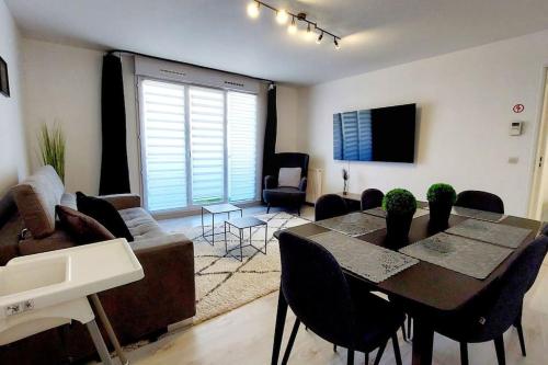 a living room with a table and a couch at Cosy Home 2 - Spacieux 3 pièces avec parking - 30 min de Paris in Cergy