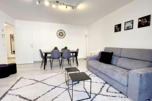 uma sala de estar com um sofá e uma mesa em Cosy Home 2, Cergy Le Haut, 6 personnes, 3 min gare, 30 min Paris, parking privé em Cergy