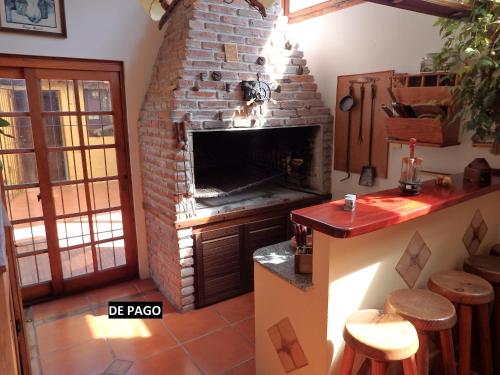 a kitchen with a brick fireplace with a counter and stools at Montelife in Montevideo