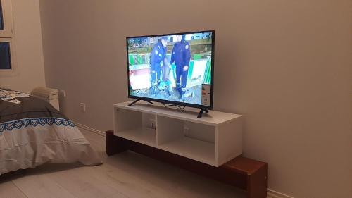 a flat screen tv sitting on a stand in a bedroom at STUDIO TRES PROPRE de 18 m2 in Cergy